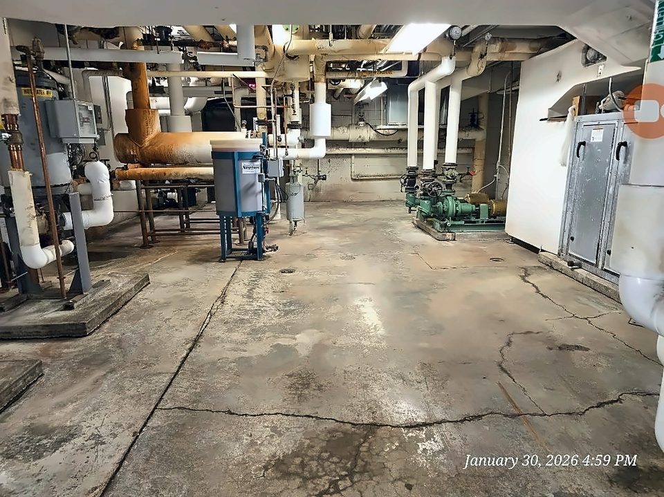 Before: cracked, uncoated slab in the same mechanical room