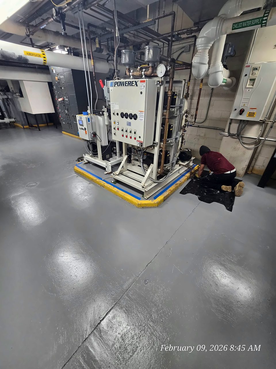 Gray epoxy floor system with yellow striping at equipment bases