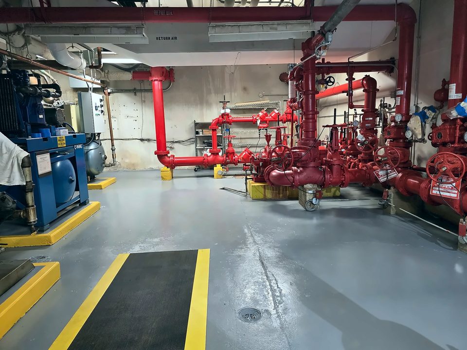 Coated mechanical-room floor with safety striping around the fire-pump piping