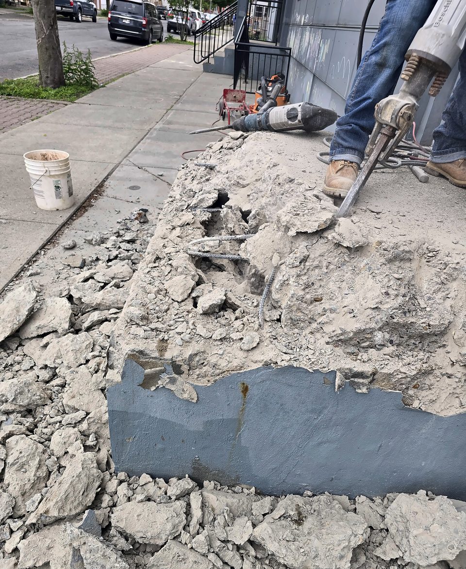 During: old stairs broken out by hand at an occupied entrance, May 2026