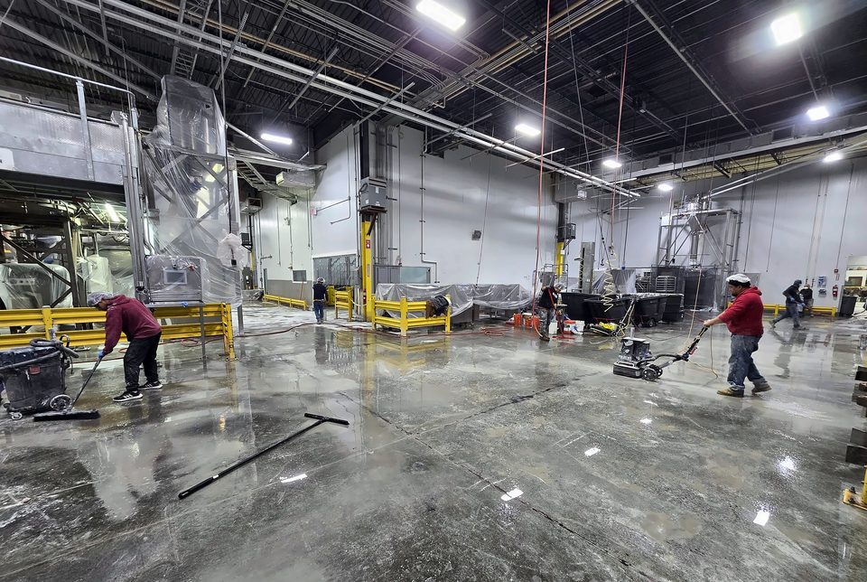 Industrial floor preparation — crew grinding a plant floor ahead of a coating system, January 2026