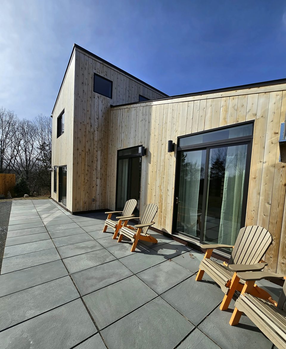 Paver patio at a modern wood-clad home, 2025