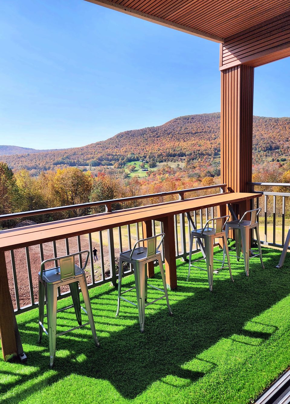Covered balcony with a wood-slat ceiling and bar rail