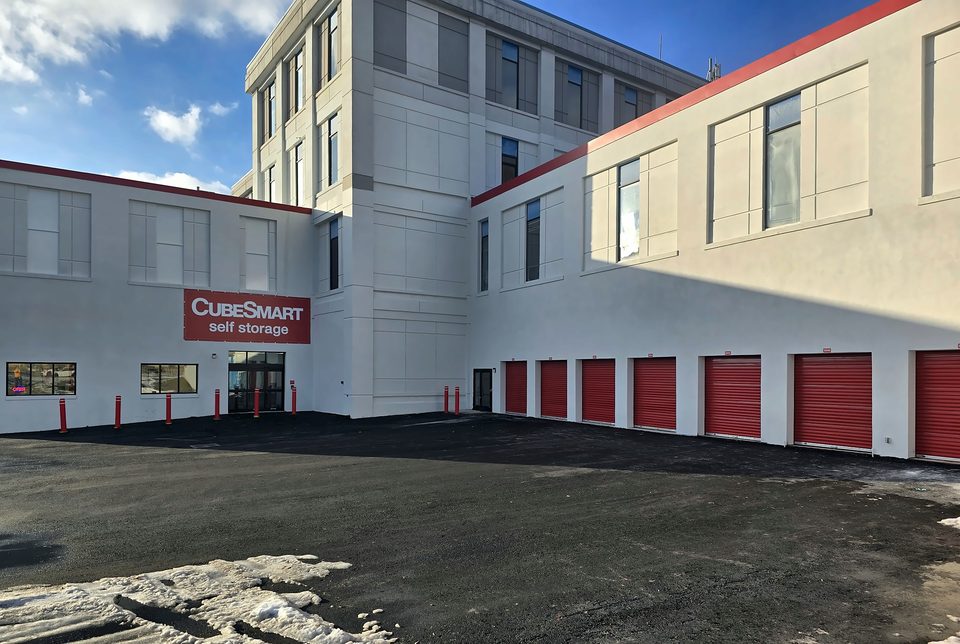 Self-storage conversion, Schenectady (2025–26): finished stucco elevation and roll-up doors, January 2026