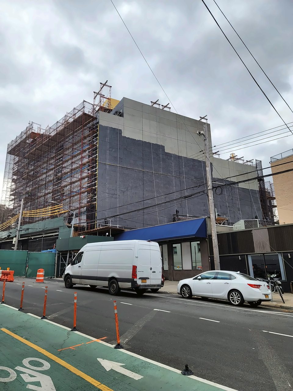 Access: pipe scaffold and debris netting on the street side