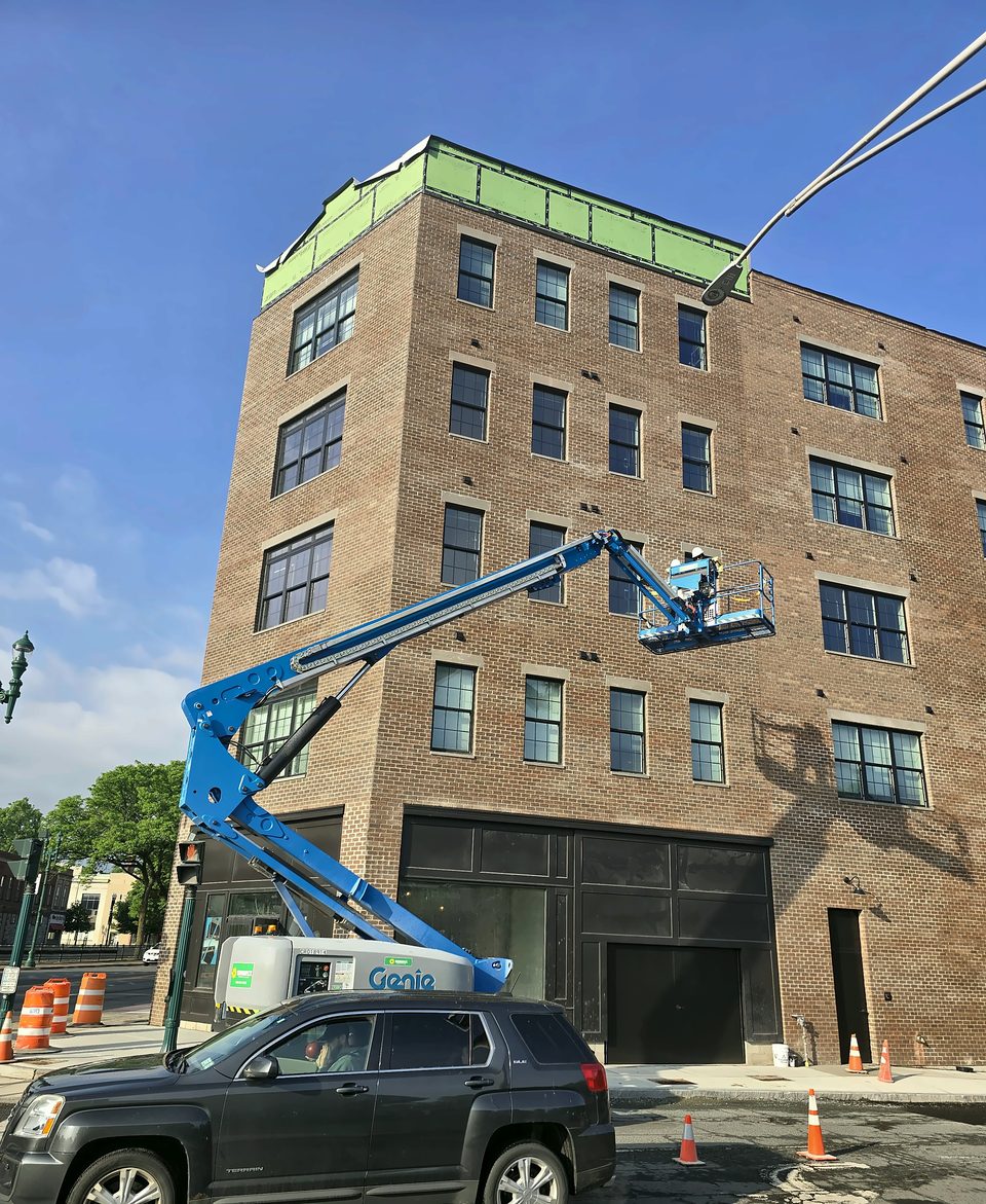 During: boom lift at the top band, sheathing exposed, June 2026