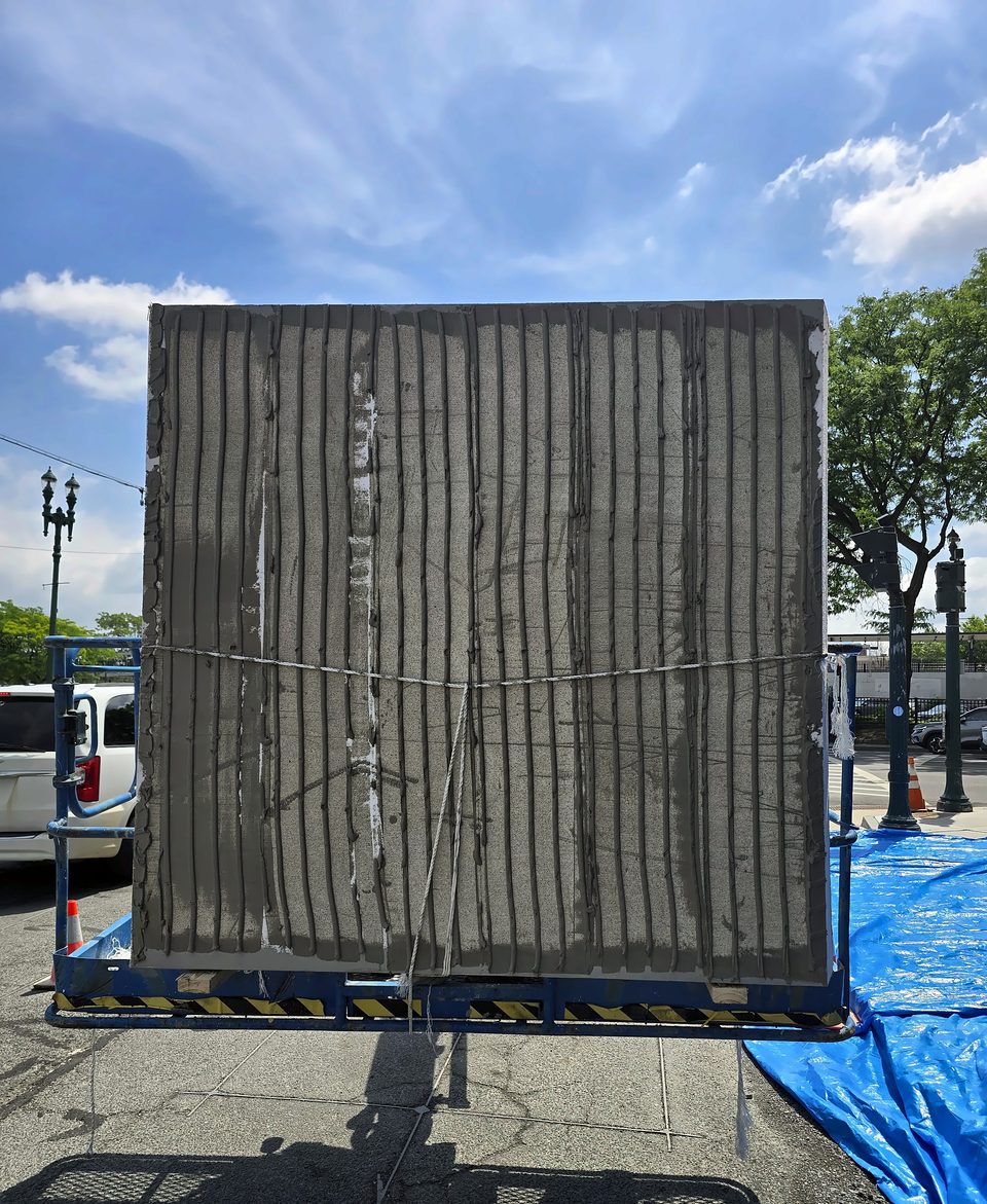 One of the owner-furnished prefabricated EIFS panels, mesh side out