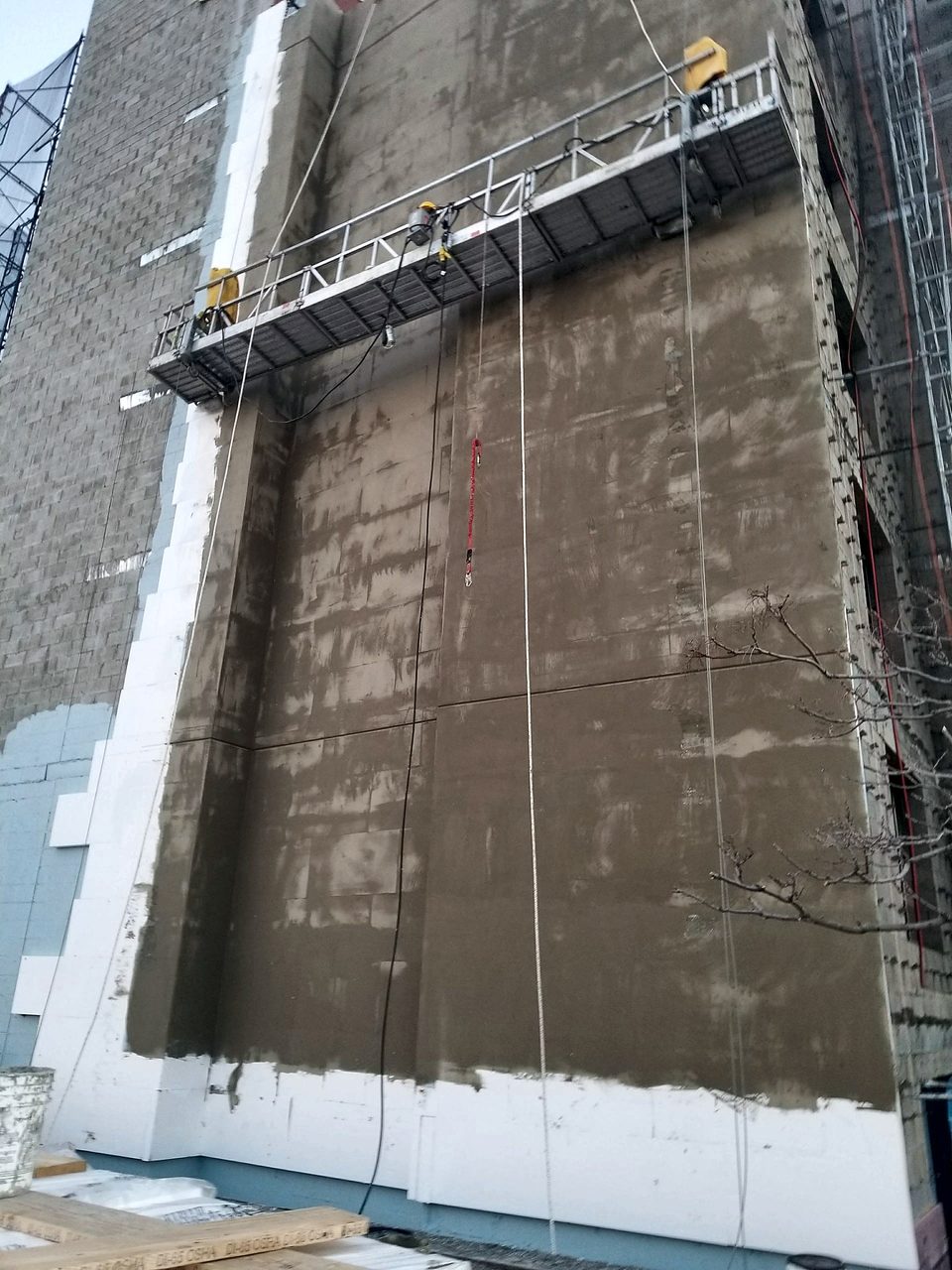 Stucco application from a suspended scaffold