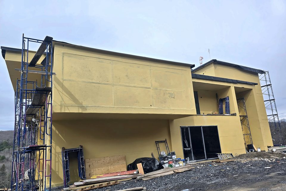 Steel Mountain Villa at basecoat stage under our scaffold, spring 2025
