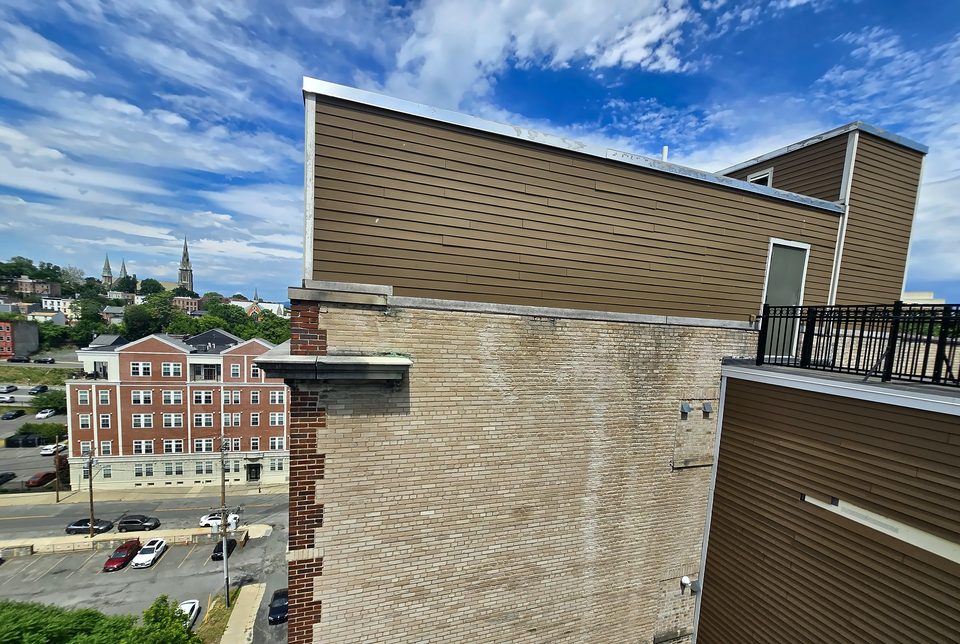 Before: the parapet and coping from the roof, June 2026