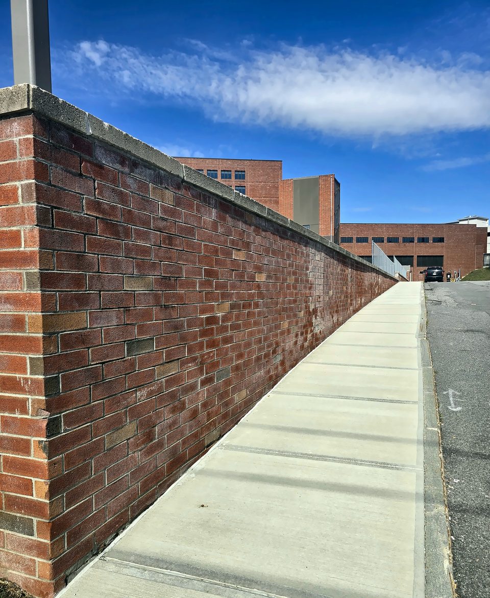 After: brick retaining wall pressure-washed and efflorescence removed, July 2026