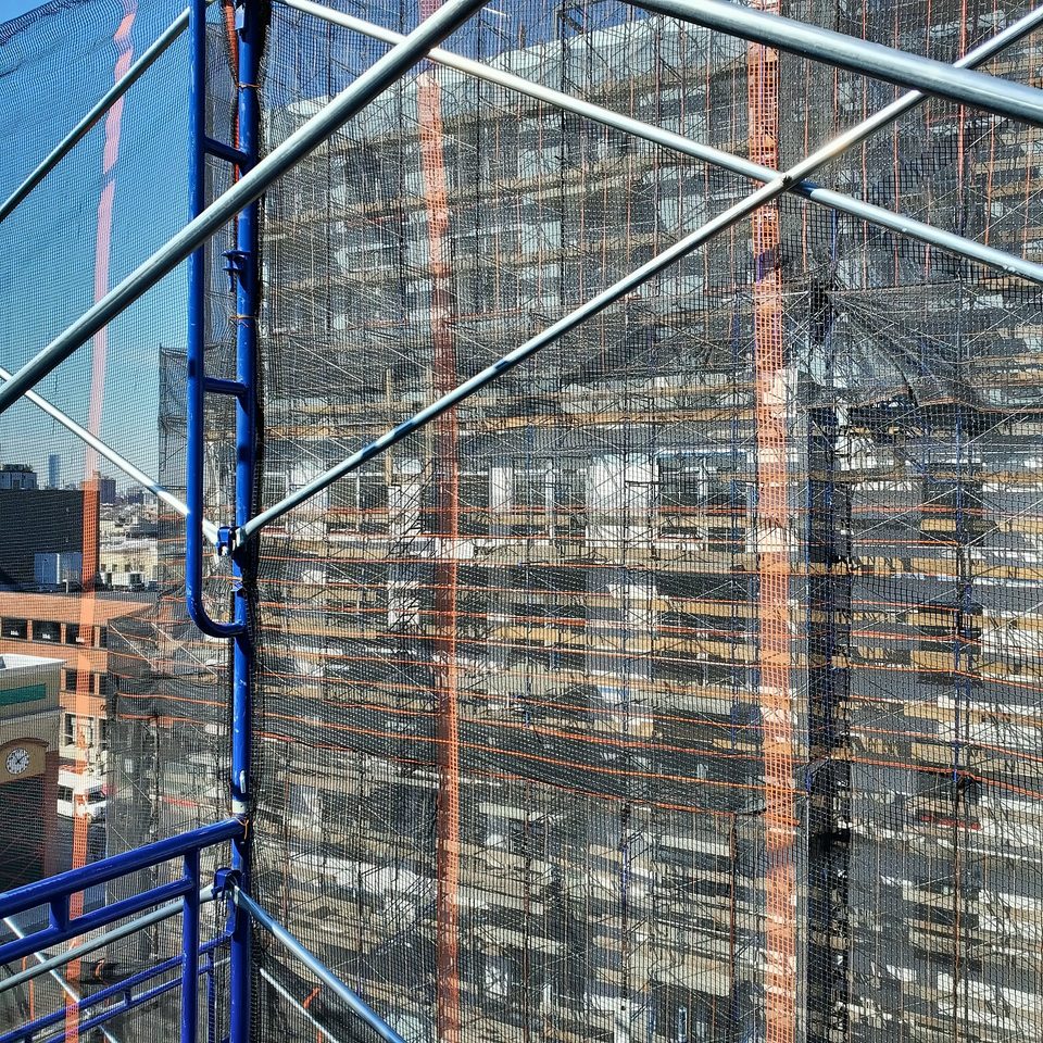 Scaffold enclosure with mesh on an urban facade