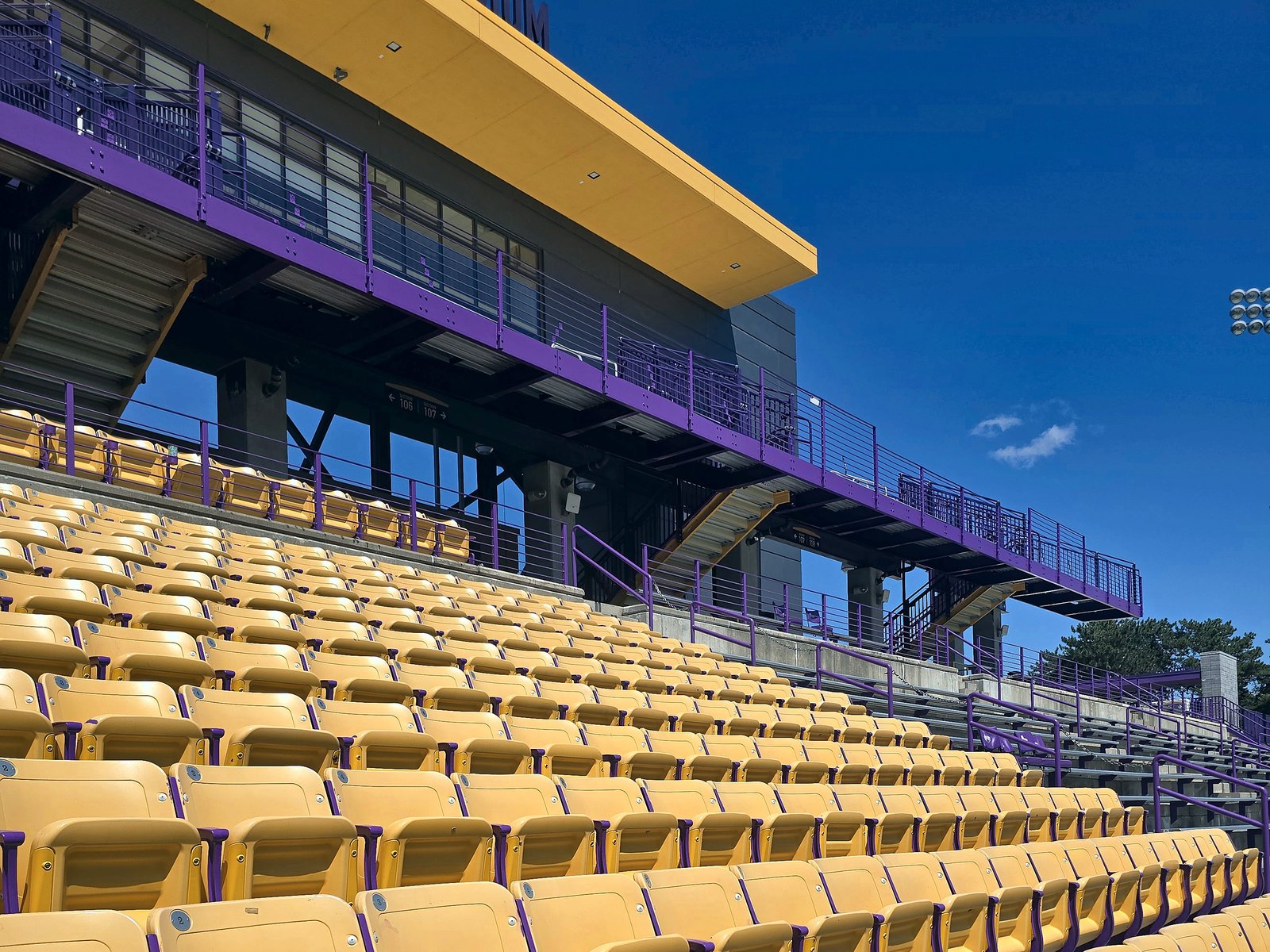 Gold stadium seats on freshly repainted purple steel risers at Casey Stadium, University at Albany