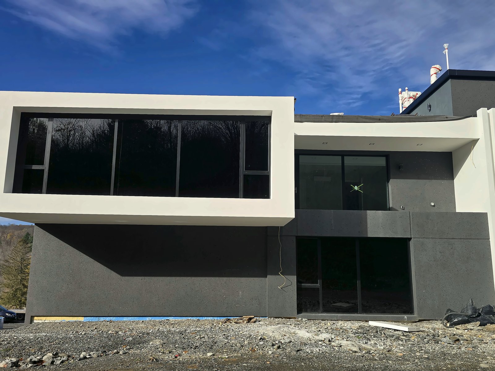 New hillside residence in the Catskills with a finished two-tone white and charcoal EIFS exterior