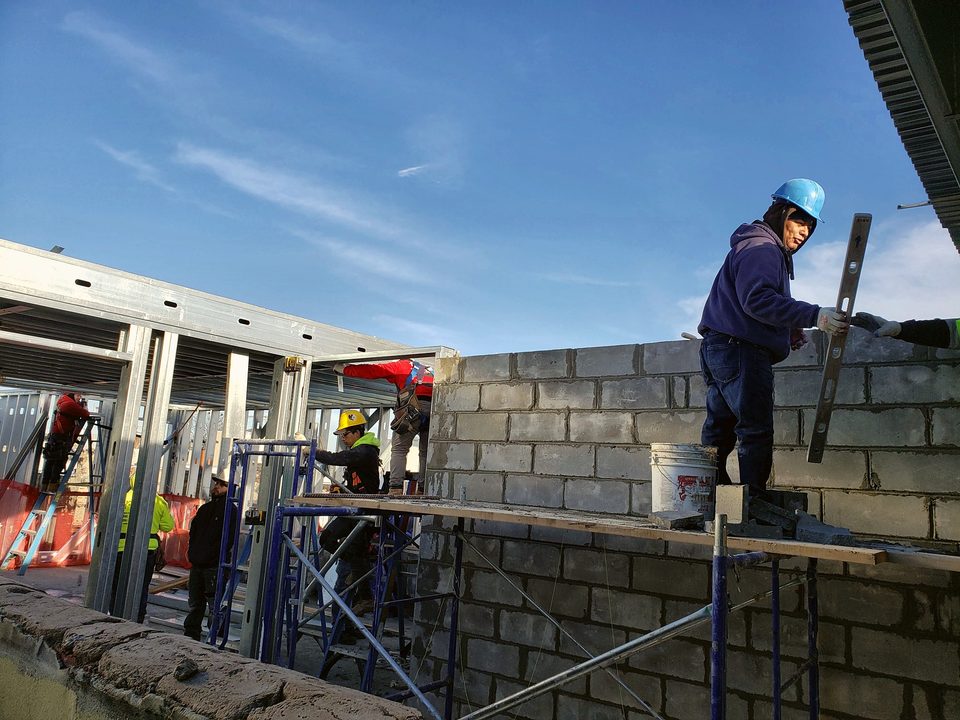 Mason laying a block wall, 2018