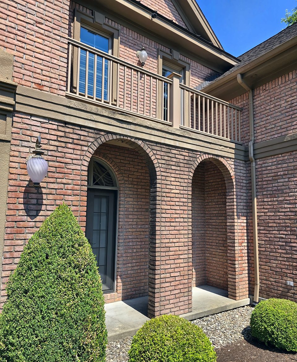 Arched brick entries and the balcony, July 2026