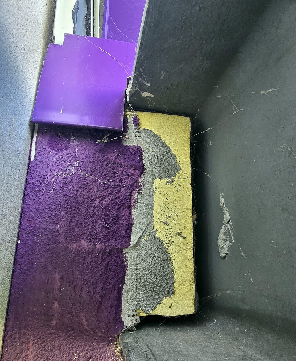 Before: failed film and rust at a column base — the condition the specification was written for