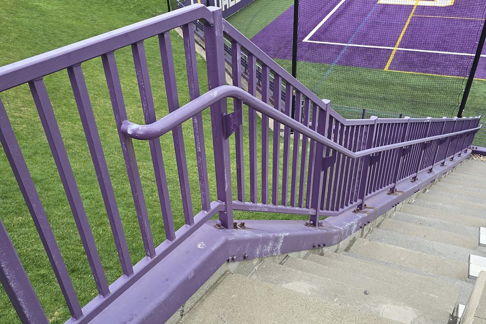 Before — chalked, faded purple coating on the stair guardrails and curb
