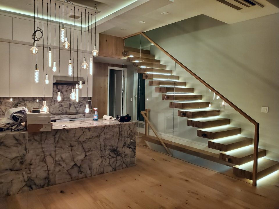 Kitchen with marble island and LED-lit floating stairs, 2020