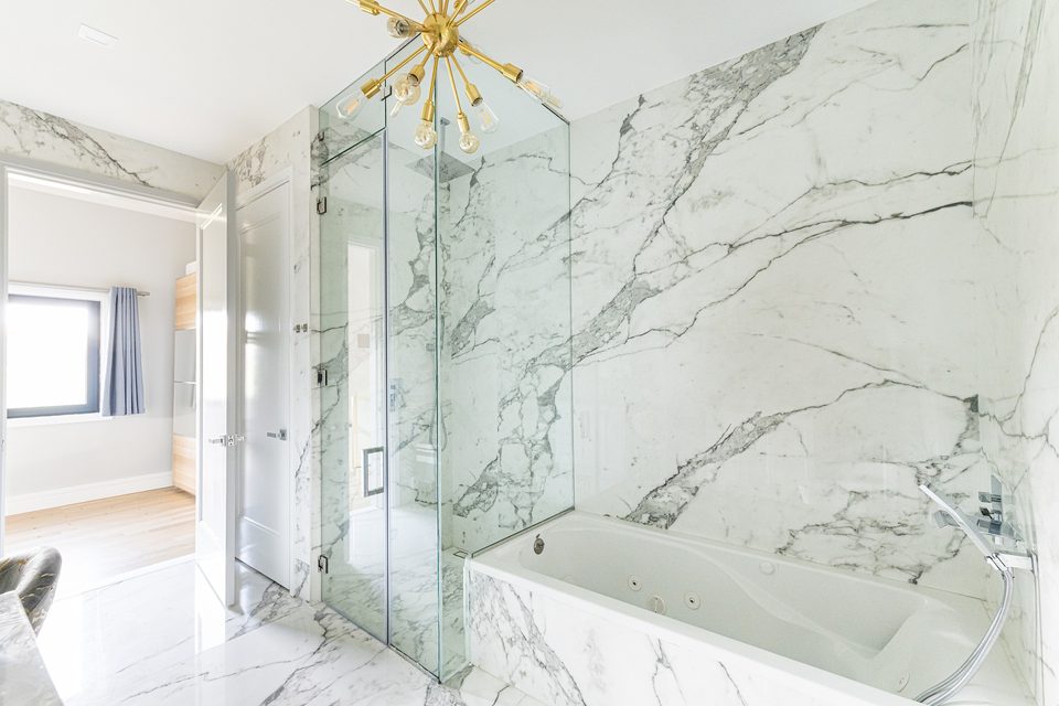 Marble-tile bathroom with glass shower and tub