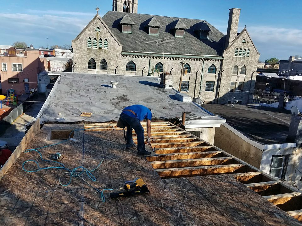 Crew rebuilding an urban flat roof, 2017