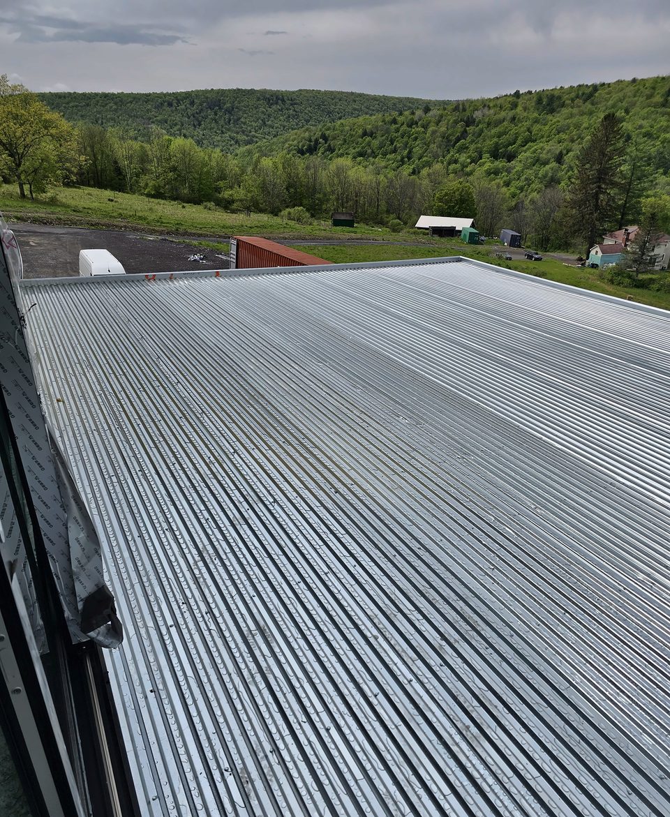 Standing-seam metal roof on a hillside home, 2025